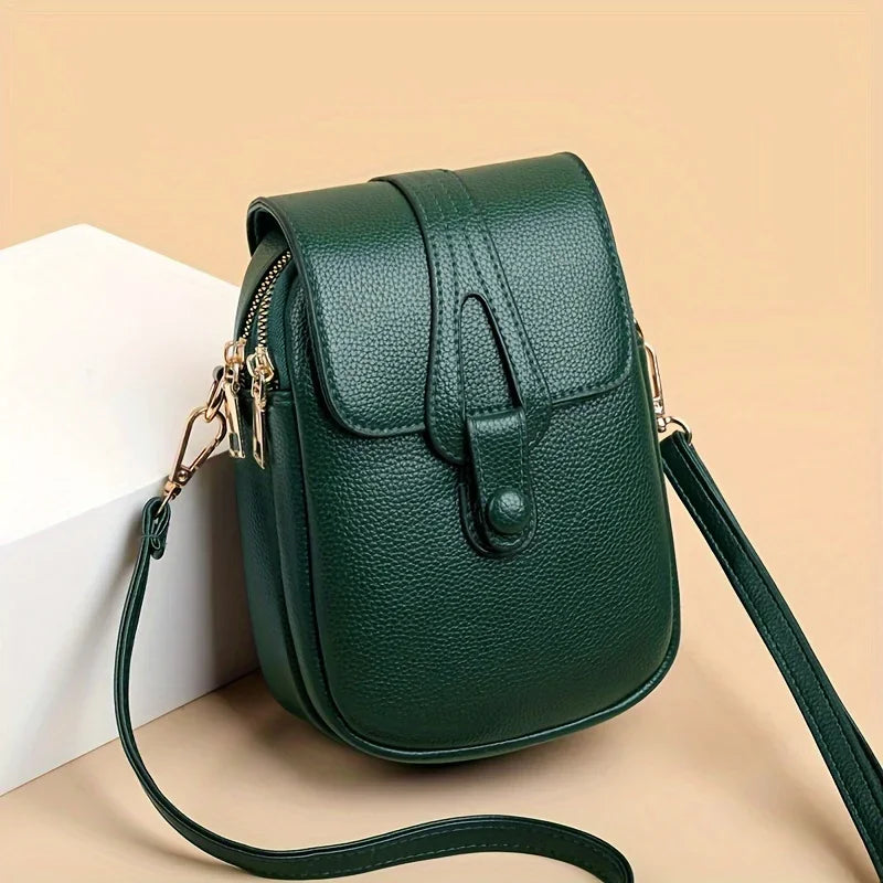 Kompakte Damen-Umhängetasche aus Leder mit minimalistischem Design und verstellbarem Riemen.