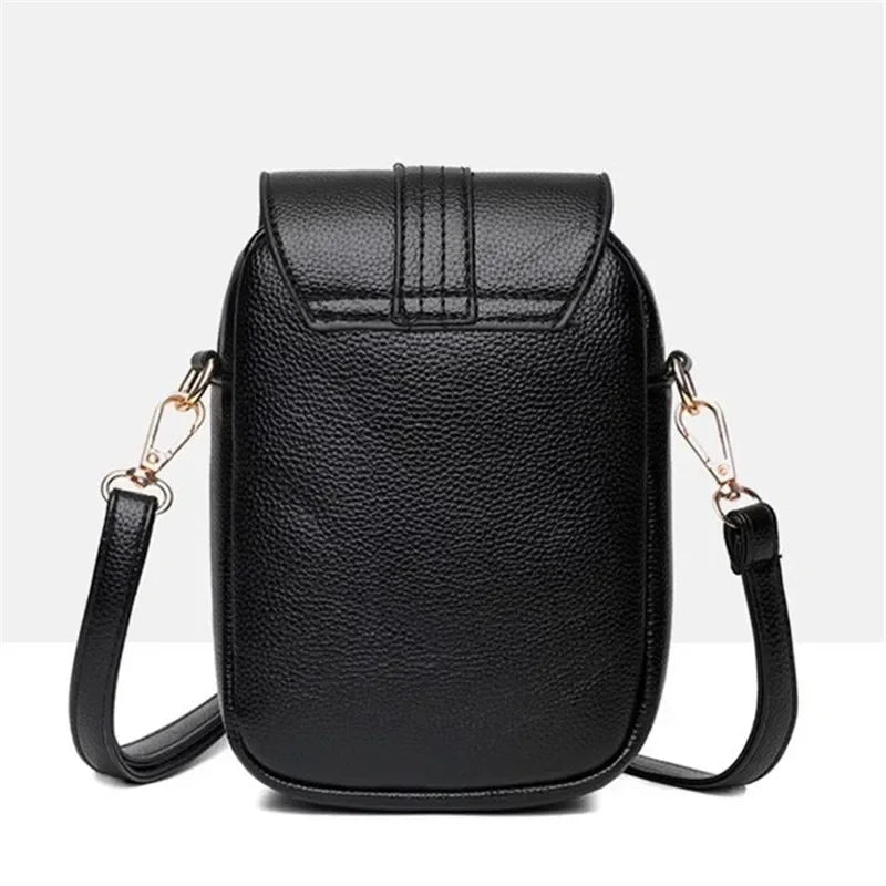 Kompakte Damen-Umhängetasche aus Leder mit minimalistischem Design und verstellbarem Riemen.